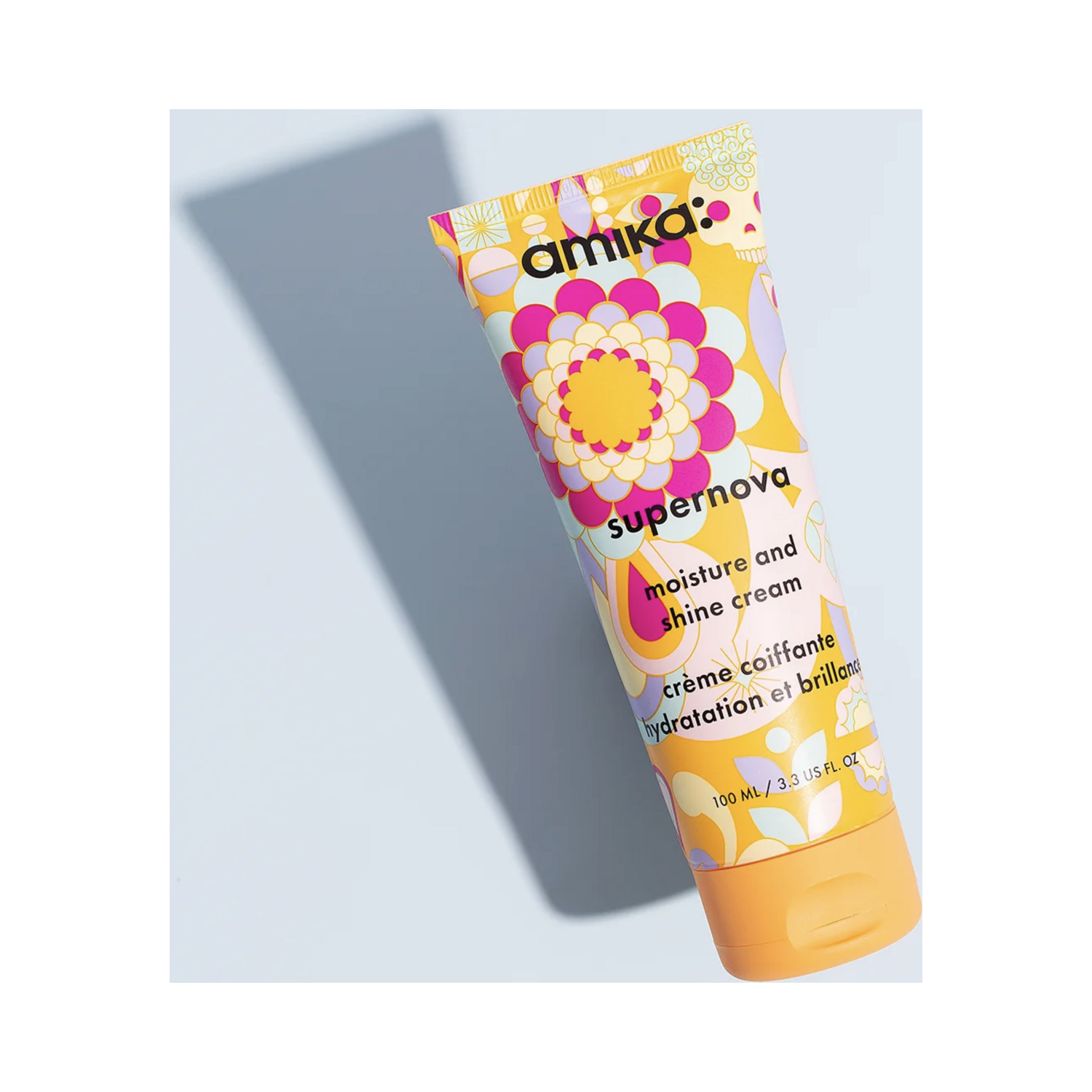 Amika Supernova Cream - Moisturizing Hair Cream displayed on blue background, highlighting vibrant packaging and benefits for hair shine and softness.