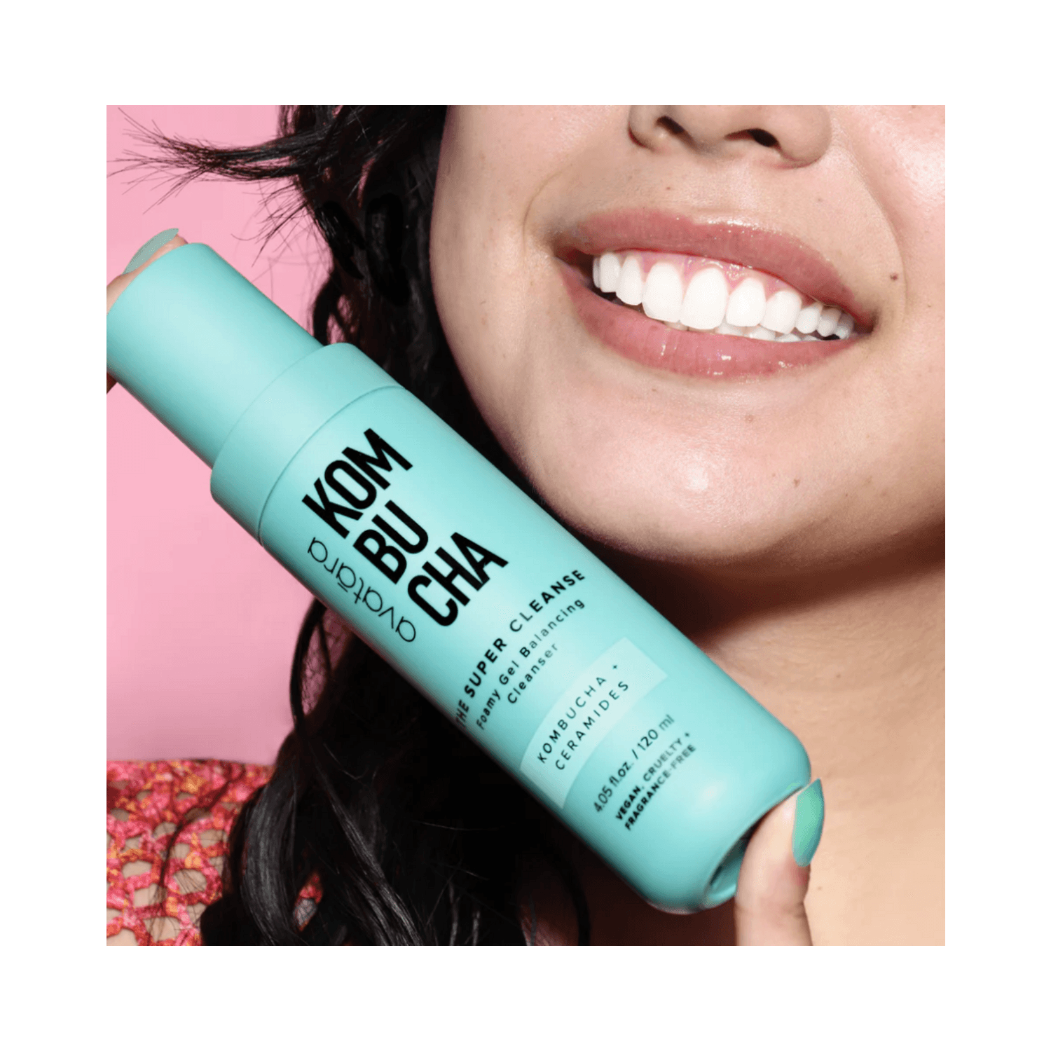 Woman holding Avatara The Super Cleanse face wash, showcasing the sleek teal packaging and its appeal for youthful skincare.