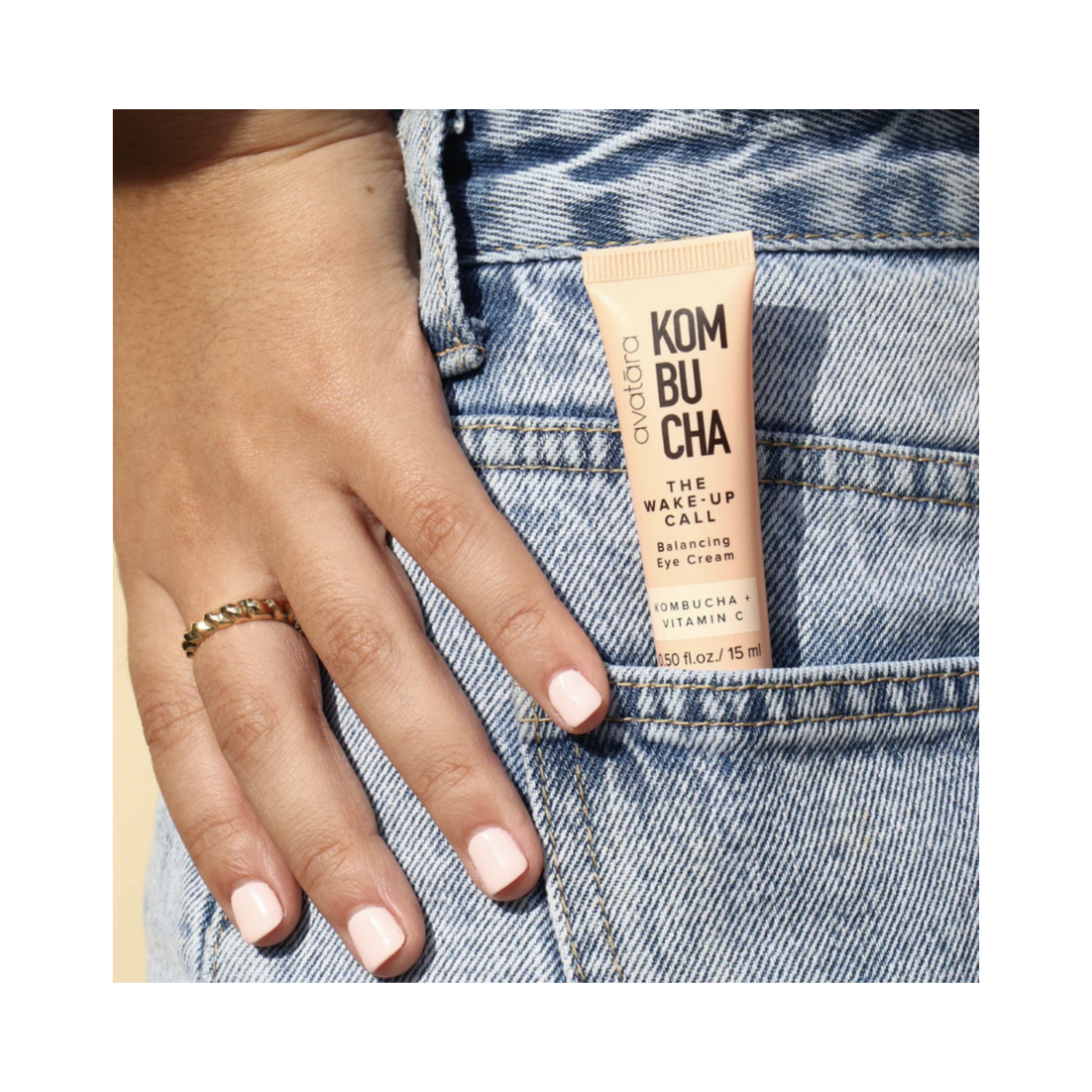 Avatara The Wake-Up Call Eye Cream tucked in denim pocket, portable skincare with Kombucha and Vitamin C for on-the-go eye hydration and brightness.