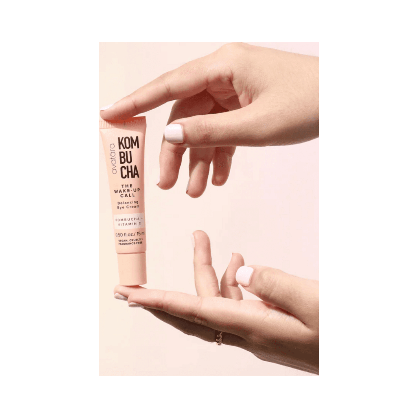 Hands holding Avatara The Wake-Up Call Eye Cream, a brightening under-eye treatment with Vitamin C and Kombucha for puffiness and hydration.
