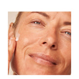 Close-up of woman applying Dr Dennis Gross Deep Cream - Vitamin C Lactic, highlighting its dewy, firming skincare effect.