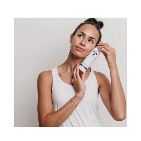 Woman holding Circadia Vitamin Veil Cleanser near her face, showcasing oil-based makeup remover for healthy skin care routine.