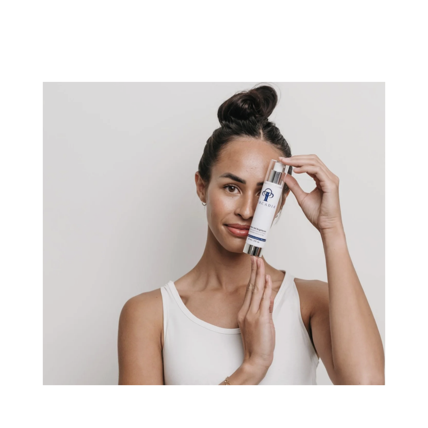 Woman holding Circadia White Veil Brightener face oil, showcasing its skin-brightening benefits for radiant, even-toned complexion in skincare routine.