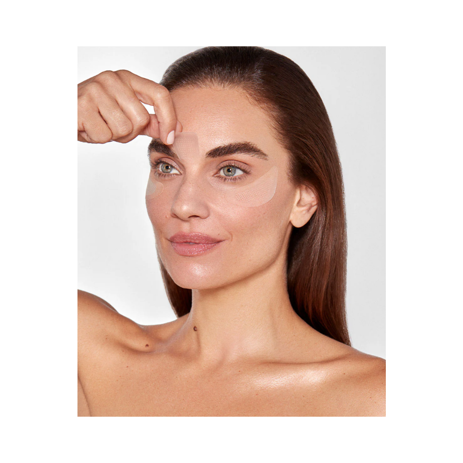 Model applying 111SKIN Wrinkle Erasing Retinol Patch to forehead, targeting fine lines. Needle-free retinol skincare treatment.